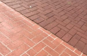 Different types of brick paving, one spray painted to concrete, the other inserted bricks